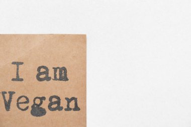 Beyaz arka planda Vegan etiketiyim. Kahverengi kağıt etiketi, siyah harfler ve bir sürü kopya alanı
