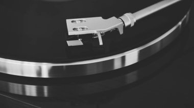 Gümüş kollu vinil plak çalar, parlak ahşap bir pikabın üzerinde. Siyah & Beyaz. 