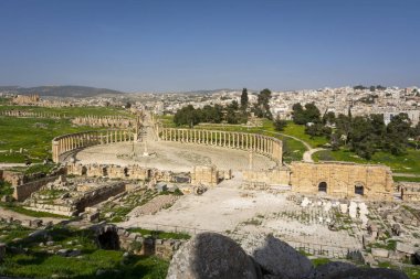 Gerasa 'nın Greko-Romen kalıntıları ve arka planda modern Jerash şehri. Oval Forum, Colonnaded Caddesi ve Cardo Maximus temiz görünüyor.. 