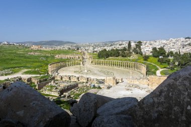 Gerasa 'nın Greko-Romen kalıntıları ve arka planda modern Jerash şehri. Oval Forum, Colonnaded Caddesi ve Cardo Maximus temiz görünüyor.. 