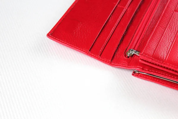 Red leather open purse lies on white surface 스톡 사진