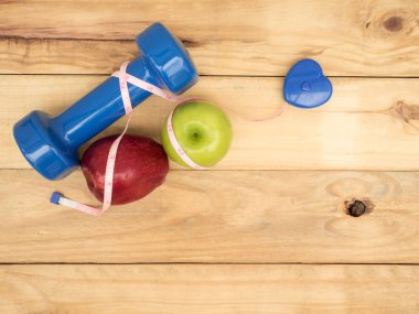 mavi dambıl ve ölçü ve kopya alanı ile ahşap arka plan üzerinde elma ile