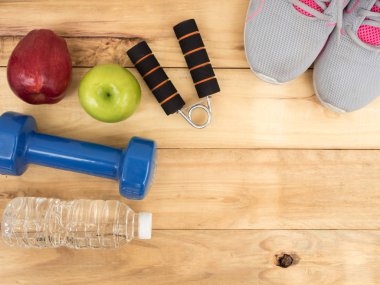 kopya alanı ile ahşap arka plan üzerinde elma ve su şişesi ile halter ve ayakkabı spor