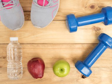 kopya alanı ile ahşap arka plan üzerinde elma ve su şişesi ile halter ve ayakkabı spor