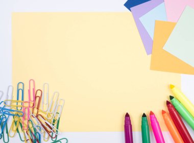 Sarı arka plan üzerinde renkli sihirli kalem ve not kağıtları ve ataş Grup desen