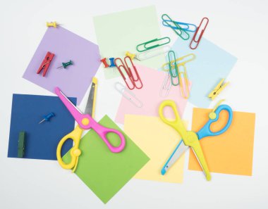 Beyaz arka plan üzerinde makas ve not defteri ile ataç ve not defteri ile tüm renkli kağıt dikkat edin