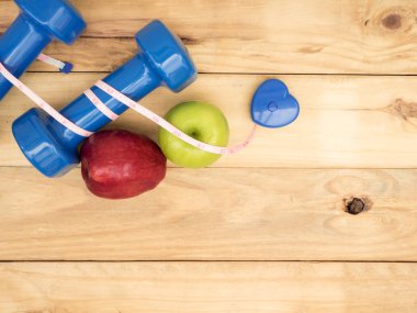 mavi dambıl ve ölçü ve kopya alanı ile ahşap arka plan üzerinde elma ile