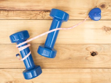 mavi dambıl ve kopya alanı ile ahşap arka plan üzerinde ölçmek