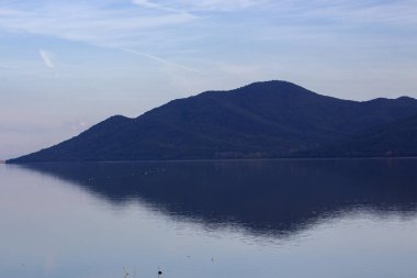 Mistik akşam manzarası. Dağ tepeleri göle yansıdı. Kerkini Gölü, Yunanistan.