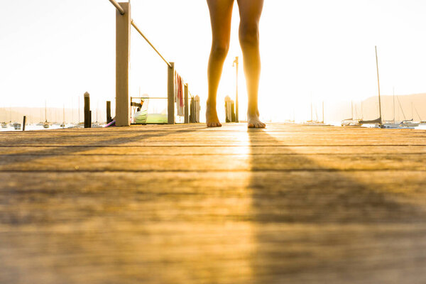 young teen on a jetty at sunset