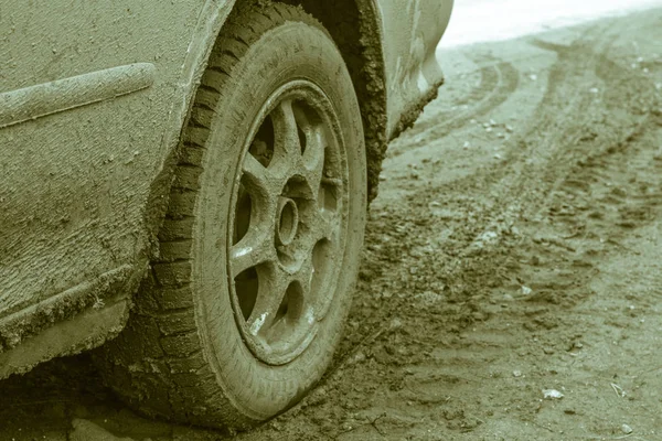 Car wheel on a dirt road. Off-road tire covered with mud, dirt t