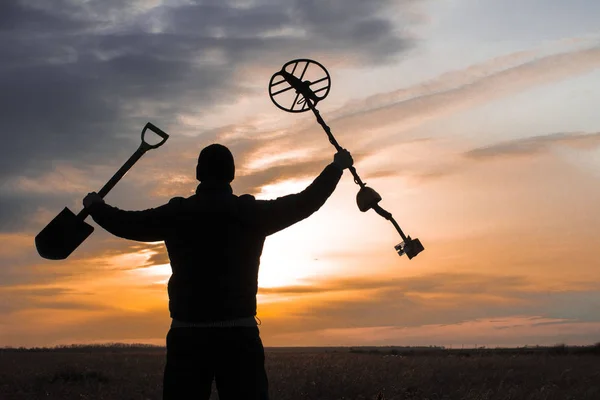 Treasure hunter with a metal detector on a beveled wheat field i — Stock Photo, Image