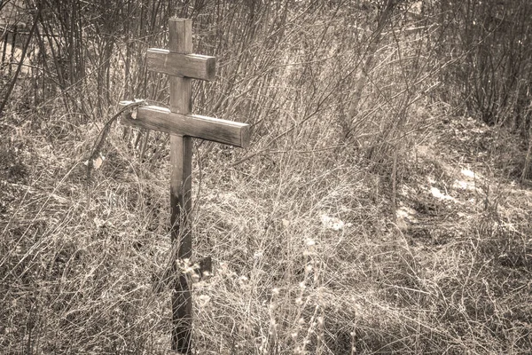 Old destroyed cross over the grave in the ancient cemetery — Stock Photo, Image