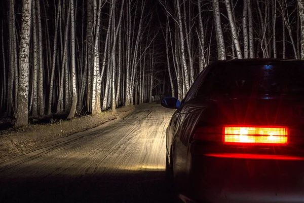 Coche deportivo blanco en una carretera de campo, en un bosque de abedul de noche — Foto de Stock