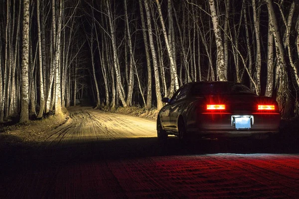 Bir gece huş ormandaki bir ülke yolda beyaz spor araba — Stok fotoğraf