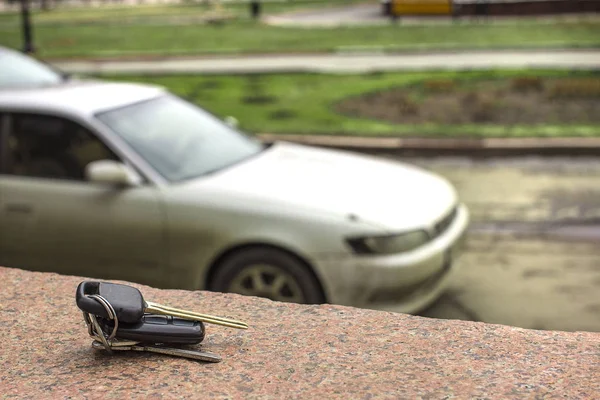 kayıp araba anahtarları üzerinde bulanık bir araba ve park backgr bir mermer levha üzerinde