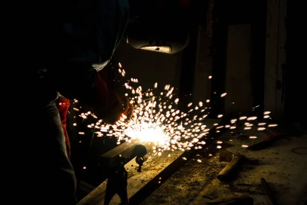 Soldador fazendo trabalho de metal à noite, frente e fundo desfocado w — Fotografia de Stock