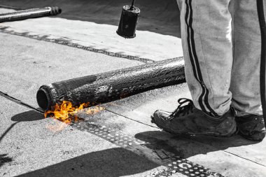 Yuvarlak yüzey malzemesi ve ateş püskürtüsü olan ziftsiz çatının tamiri