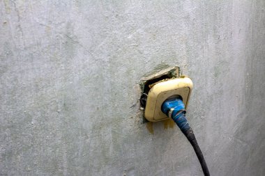 Elektrik prizi tamiratında çalışan zavallı yaşlı elektrikçi.