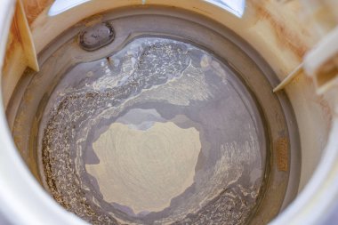 Ölçek, beyaz izole edilmiş arka planda eski bir çaydanlıkta pullar,