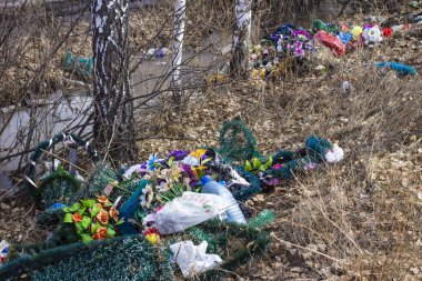 Ormanın kenarındaki bir mezarlıktan atılmış çelenkler.