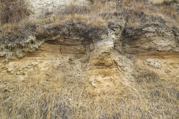 Fotografia naturale di un taglio di uno strato di terra e argilla su una rupe — Foto Stock
