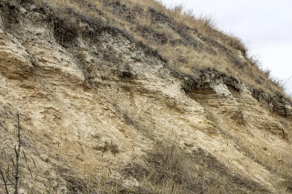 Fotografia naturale di un taglio di uno strato di terra e argilla su una rupe — Foto Stock