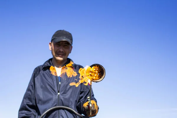 Um queimador com um incêndio em um fundo desfocado de um telhados de trabalho — Fotografia de Stock