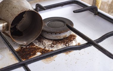 Cezve 'den dökülen kahveyle birlikte kirli gaz sobası.