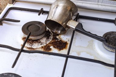 Cezve 'den dökülen kahveyle birlikte kirli gaz sobası.