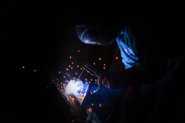 Schweißer bei Metallarbeiten in der Nacht, Vorder- und Hintergrund verschwommen — Stockfoto