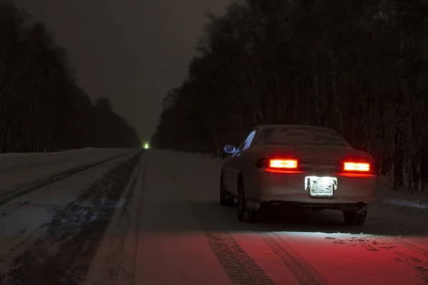 Sports car at night on a winter icy road in the absence of traff — Stock Photo, Image