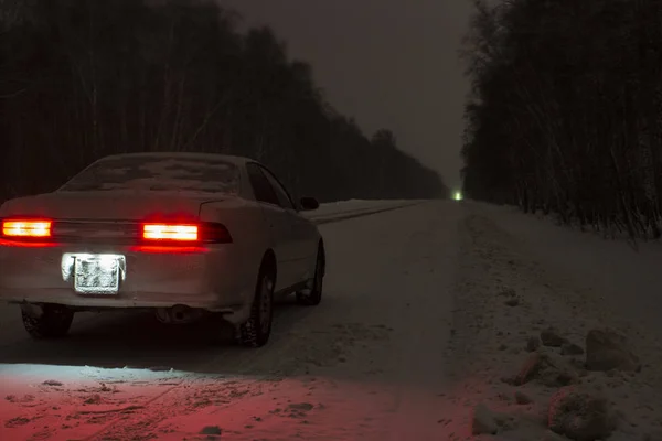 Спортивний автомобіль вночі на зимовій крижаній дорозі за відсутності торгівлі — стокове фото