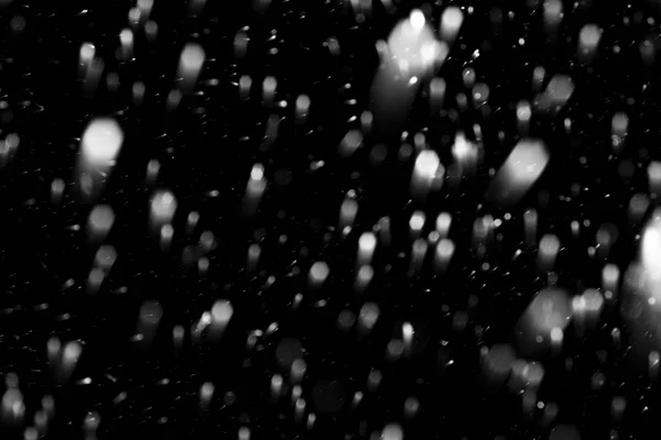 Fiocchi di neve che cadono velocemente contro un cielo nero, la parte anteriore e b — Foto Stock