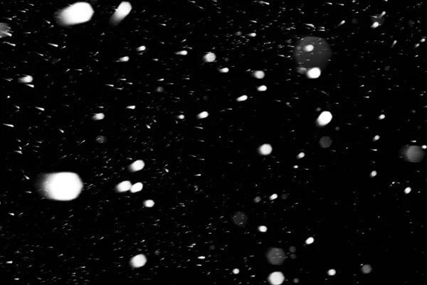 Flocos de neve caindo rápido contra um céu negro, a frente e b — Fotografia de Stock