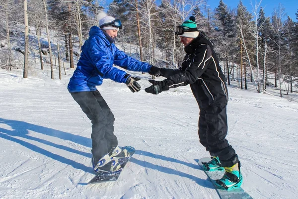 Dívka studující snowboarding s instruktorem na sjezdovce — Stock fotografie