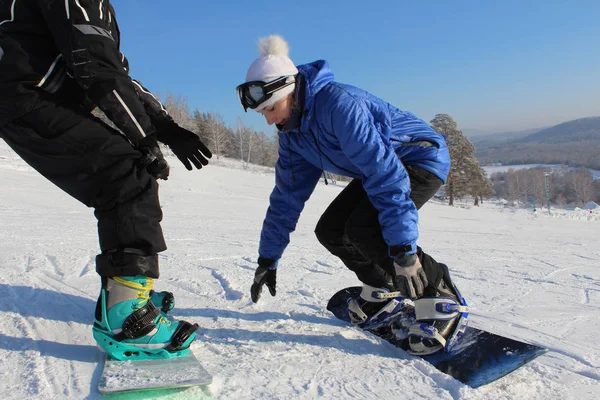 Dívka studující snowboarding s instruktorem na sjezdovce — Stock fotografie