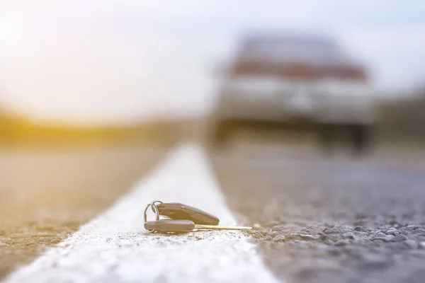 Kayıp araba anahtarları, bulanık bir arka planda yol üzerinde yatıyor. — Stok fotoğraf