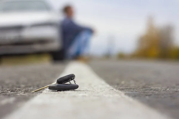 Llaves de coche perdidas que yacen en la carretera, sobre un fondo borroso con — Foto de Stock