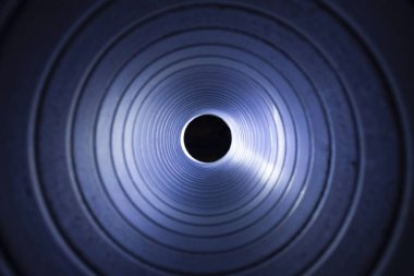 Arka plandaki egzoz vantilatöründeki galvanize çelik hava kanalının içerisinden yakın çekim görüntüsü Bokeh etkisi ile ön ve arka plan bulanıklaşır.