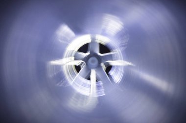 Arka plandaki egzoz vantilatöründeki galvanize çelik hava kanalının içerisinden yakın çekim görüntüsü Bokeh etkisi ile ön ve arka plan bulanıklaşır.