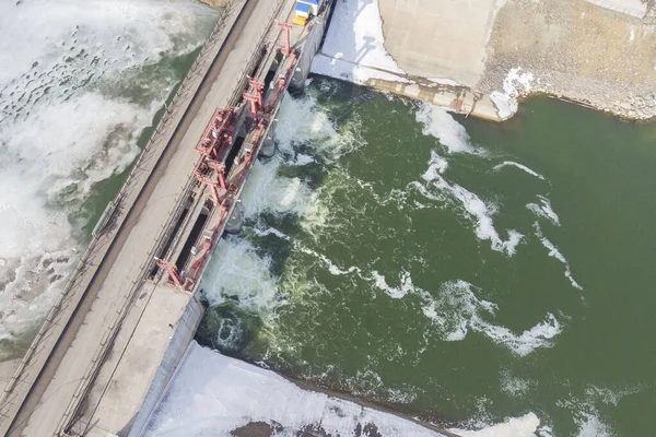 filled dam at the beginning of the flood with ice, aerial view from the drone