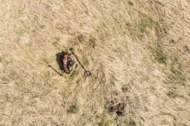 Eski bir yerleşim yerinde metal dedektörü olan bir adam İHA 'dan fotoğrafını çekmiş.
