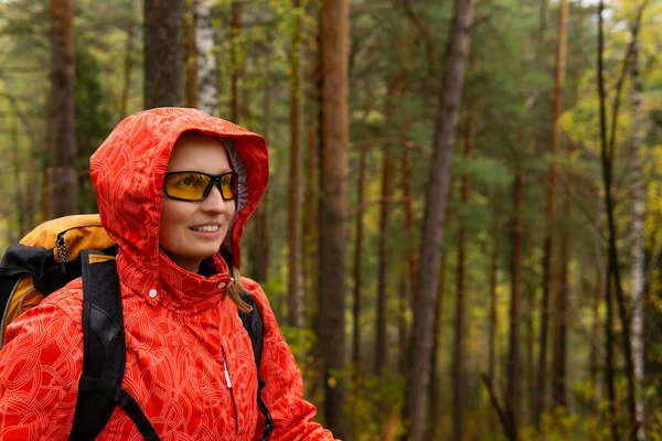 Glimlachende vrouwelijke reiziger in het herfstbos — Stockfoto