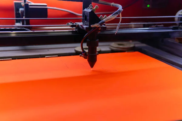 Лазерная резка на листе оранжевого материала — стоковое фото