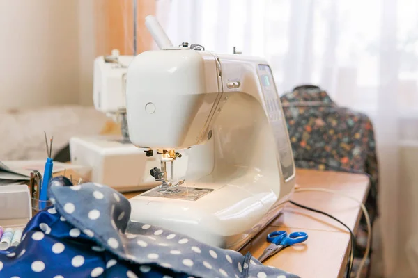 Fabric and ready-to-use sewing machine on a table in a room — Stock Photo, Image