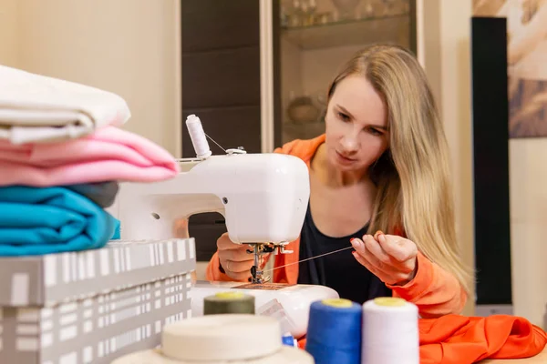 女裁缝在缝纫机的针头上穿线 — 图库照片