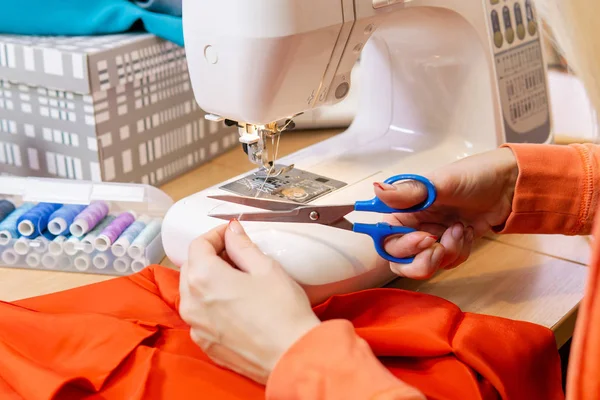 Seamstress cuts the sewing machine thread, close-up — Stock Photo, Image