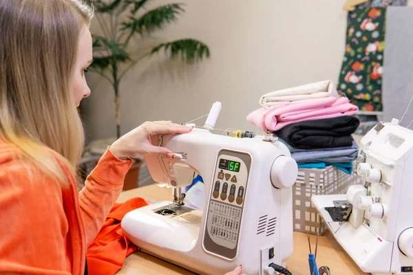 Seamstress adjusts the speed of the sewing machine — Stock Photo, Image