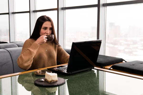 Giovane donna che lavora su un computer portatile in una caffetteria — Foto Stock